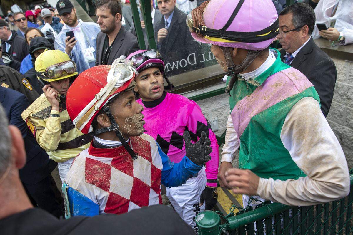 Jockey Flavien Prat, left, who rode Country House, who was declared the winner of the 145th Kentucky Derby, talks on the phone to the stewards as other jockeys, including Luis Saez, third from left, who finished first but was disqualified, talks following the Derby.