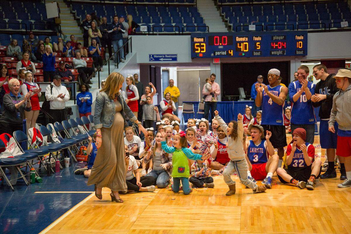 Lafayette coach Allison Tate Denton, left, reaches for daughter Anna Clay as she is introduced as Lafayette receives their trophy after the Generals beat Paul Laurence Dunbar 53-40 in the 11th Region Championship game on March 9, 2014, at the Frankfort Convention Center in Frankfort.