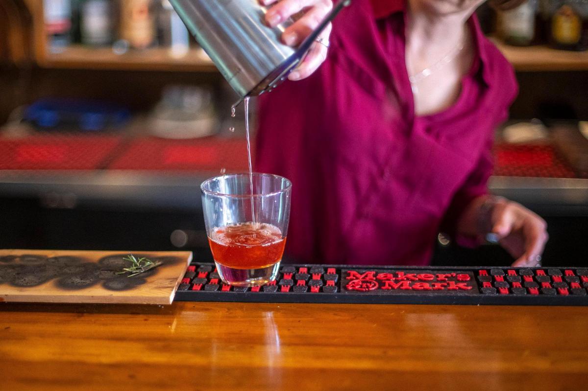 Rebecca Romero prepares a smoked old fashion at Romero’s, which has a bar for craft cocktails.