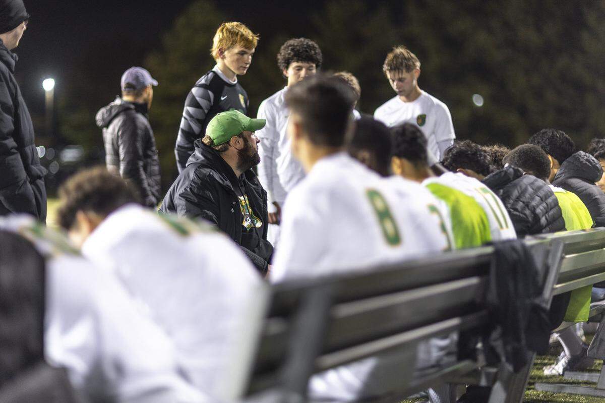 Bryan Station soccer coach Alex Tungate, center left seated, speaks to his team at halftime during a match against St. Xavie game on Wednesday, Nov. 5, 2025.