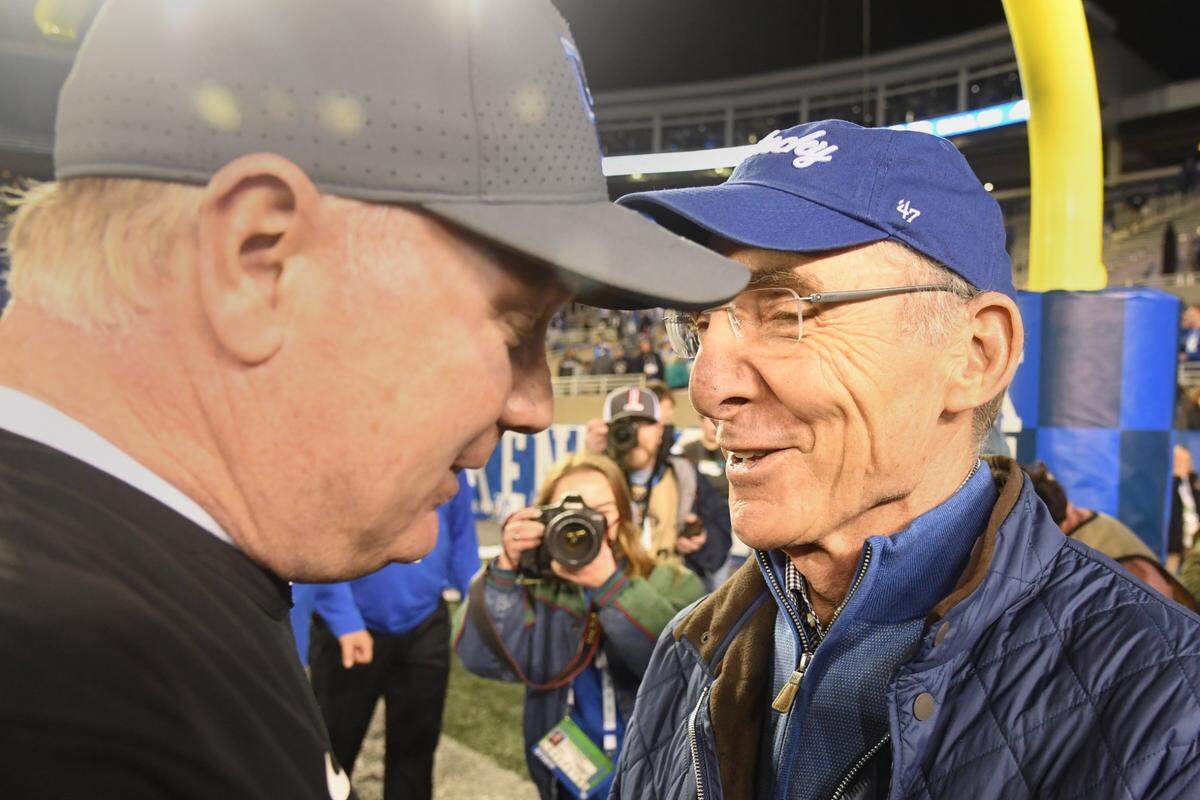 UK head coach Mark Stoops is congratulated by UK President Eli Capiluto following Saturday’s win against Louisville at Kroger Field.