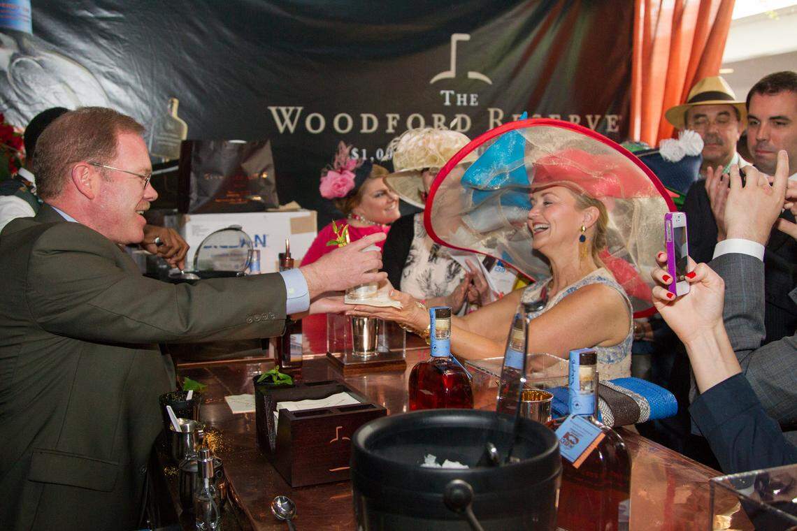 Chris Morris, Master Distiller at Woodford Reserve distillery, prepares a mint julep for Anita Cauley, right with hat, in the Brown Forman tent before the 139th running of the Kentucky Derby at Churchill Downs in Louisville, Ky. Saturday May 4, 2013.  Photo by Mark Mahan