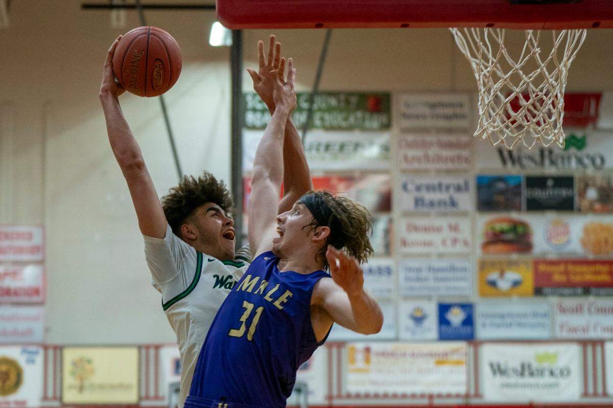 Great Crossing’s Malachi Moreno, left, challenges Male’s Jayson Gasaway during a game in the Dan Cummins Classic at Scott County on Jan. 20.