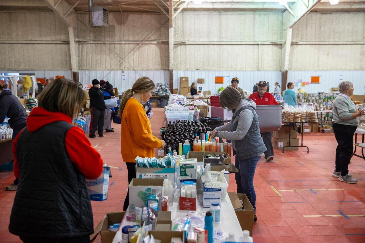 Volunteers sort donated supplies at the Mayfield-Graves County Fairgrounds on Monday, Dec. 20, 2021, for those impacted by a tornado that hit the community earlier in December.
