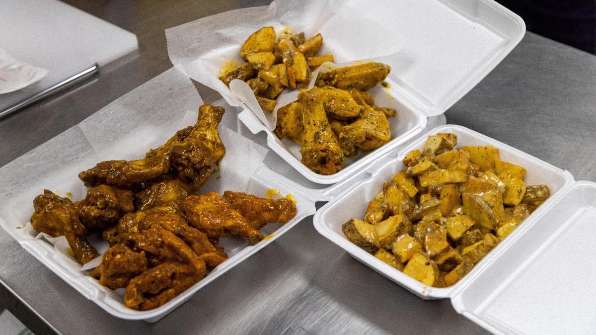 Dirt Bowl Classic Skywalker wings, left, chopped potatoes and Easy World wings, center, and a large container of chopped potatoes, right, from Wing KYing.