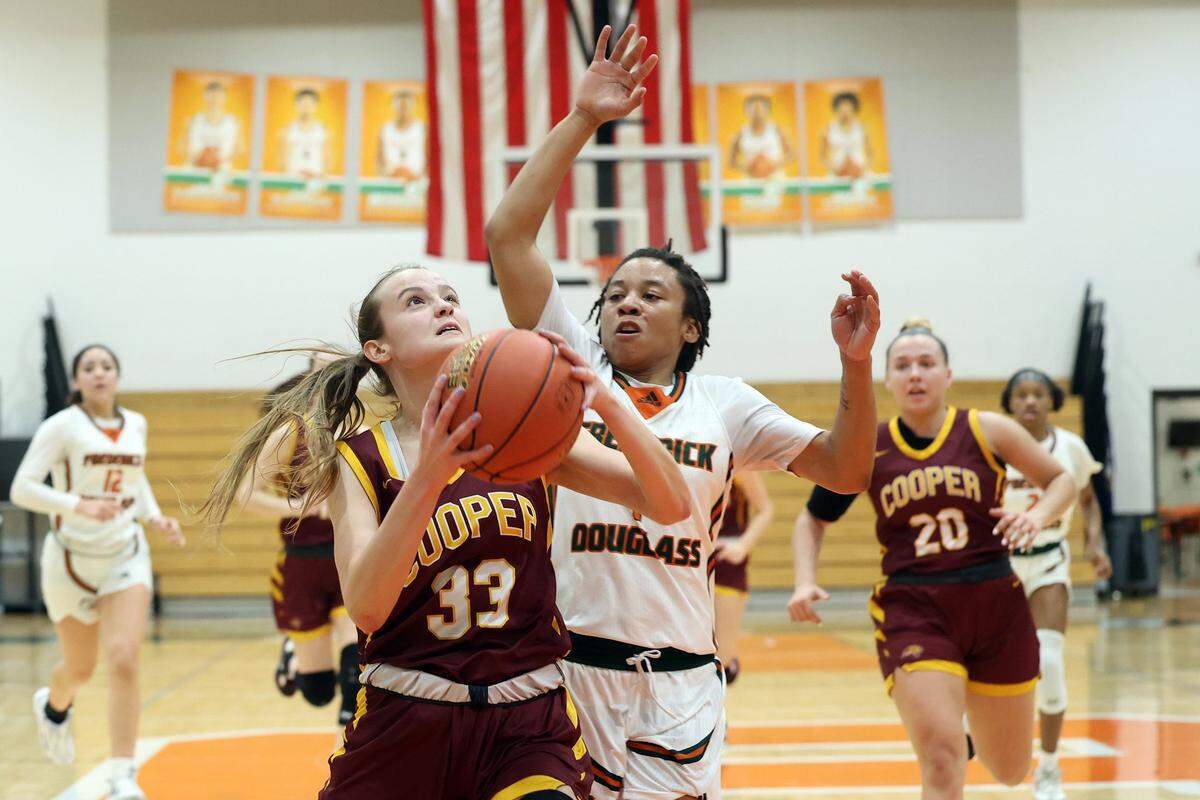 Cooper’s Logan Palmer (33) shoots while defended by Frederick Douglass’ Jer’Myra Christian during their game in Lexington on Friday, Feb. 10.