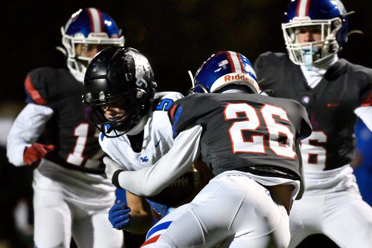 Christian Academy’s Micah Newsome (26) wraps up Lexington Catholic’s Duncan Gaunce (5) for a loss during the first half on Friday night.