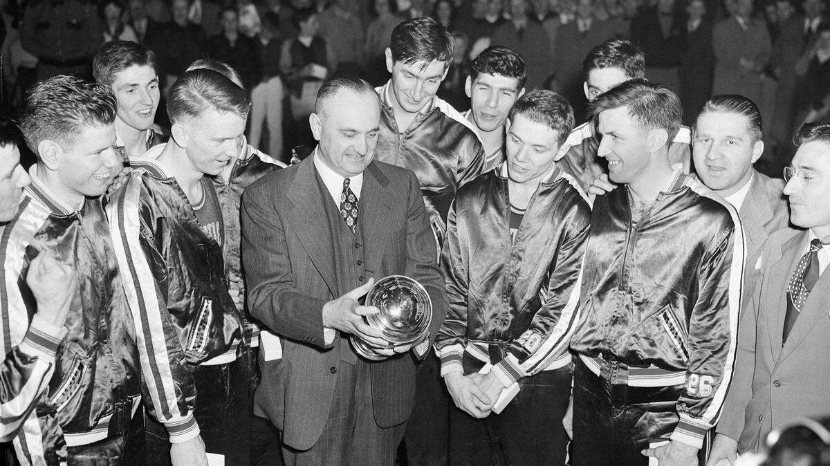 Coach Adolph Rupp and his Kentucky Wildcats admired the NCAA trophy, which they won in Seattle by defeating Oklahoma A&M on March 26, 1949. Players in front with Rupp were Jim Line and Walter Hirsch, left, and Ralph Beard and Clifford Barker, right.