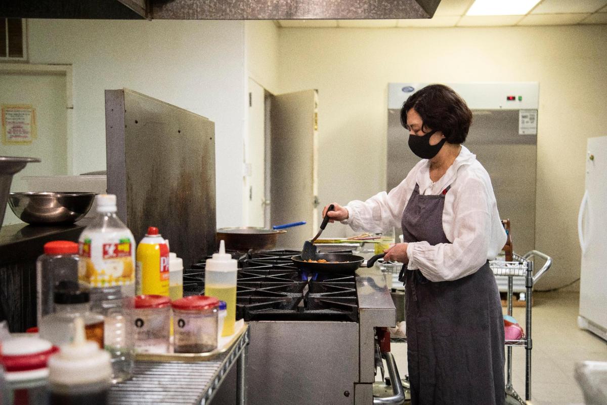 Jeeyoun Kim-Yi creates dishes over a stove in the kitchen at Korean restaurant JY Kitchen.
