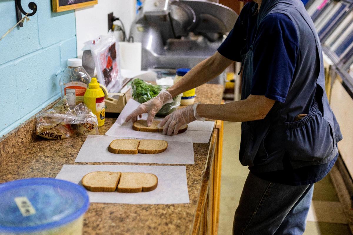 Lucia Grammel makes sandwiches August 20 in the deli of Fitch’s IGA Grocery in Wilmore. Grammel has been working at the store for two years making and serving lunches to customers and regulars.