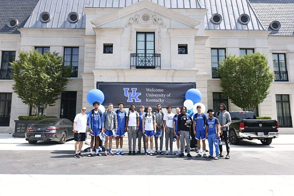 John Calipari and Kentucky’s basketball players pose in front of a banner welcoming the Wildcats to Drake’s mansion in the Toronto area Friday afternoon.
