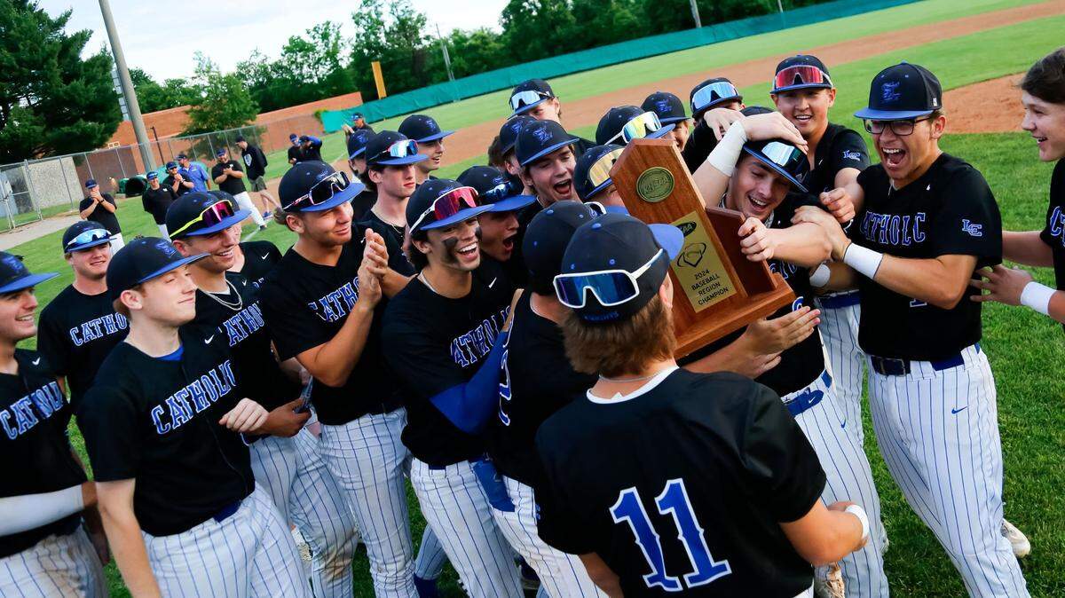 Lexington Catholic won last year’s 11th Region baseball tournament. Here, the Knights’ Tyler Nighbert (with trophy) was jostled by his teammates in celebration following their 2-0 win against Franklin County in finals at Bryan Station High School on May 29, 2024.