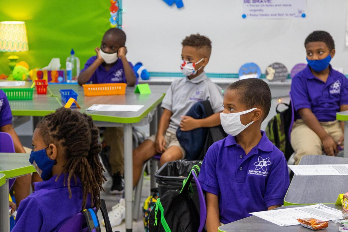 Second-graders at Carter G Woodson Preparatory Academy listened intently to their teacher on classroom etiquette for their first day of school.