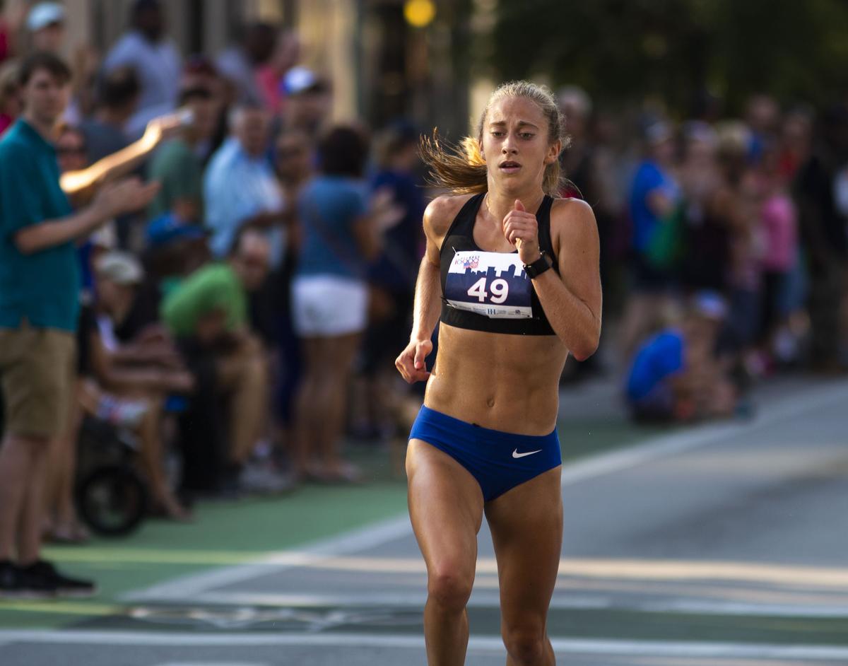 Katy Kunc, 22, crossed the finish line to take first place in the women's division in the 42nd Bluegrass 10K race in downtown Lexington on Wednesday.