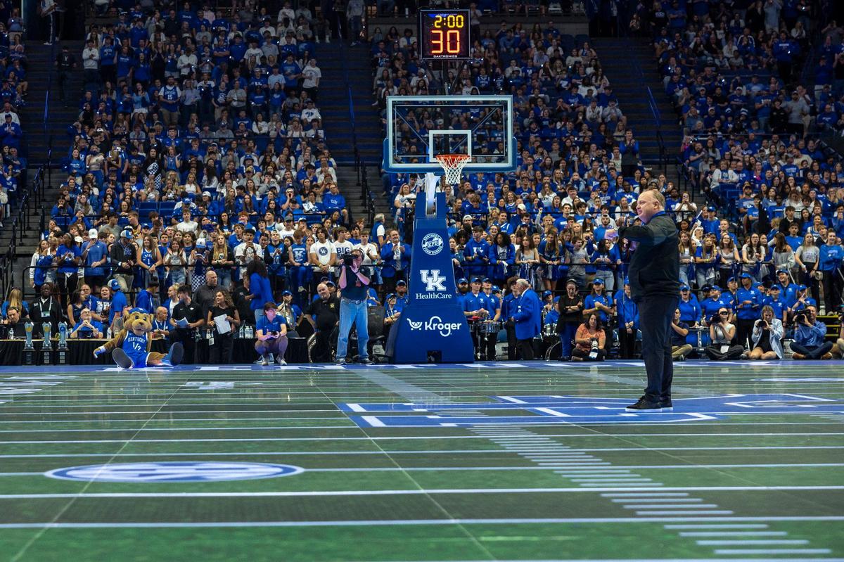 Kentucky football coach Mark Stops talks to the Rupp Arena crowd as the interactive LED basketball court brought in for Big Blue Madness changes to a replica of Kroger Field.