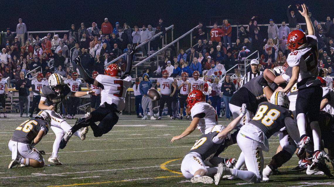 Cardinals Asher Brewer (3) fails to block Yellow Jackets Cash Wolfe (41) from kicking a successful field goal, tying the game 24 - 24 in the third quarter during the Class 5A Region Championship game between Scott County and Woodford County on Nov. 21, 2025, at the Community Stadium at Falling Springs Center in Versailles, Ky.