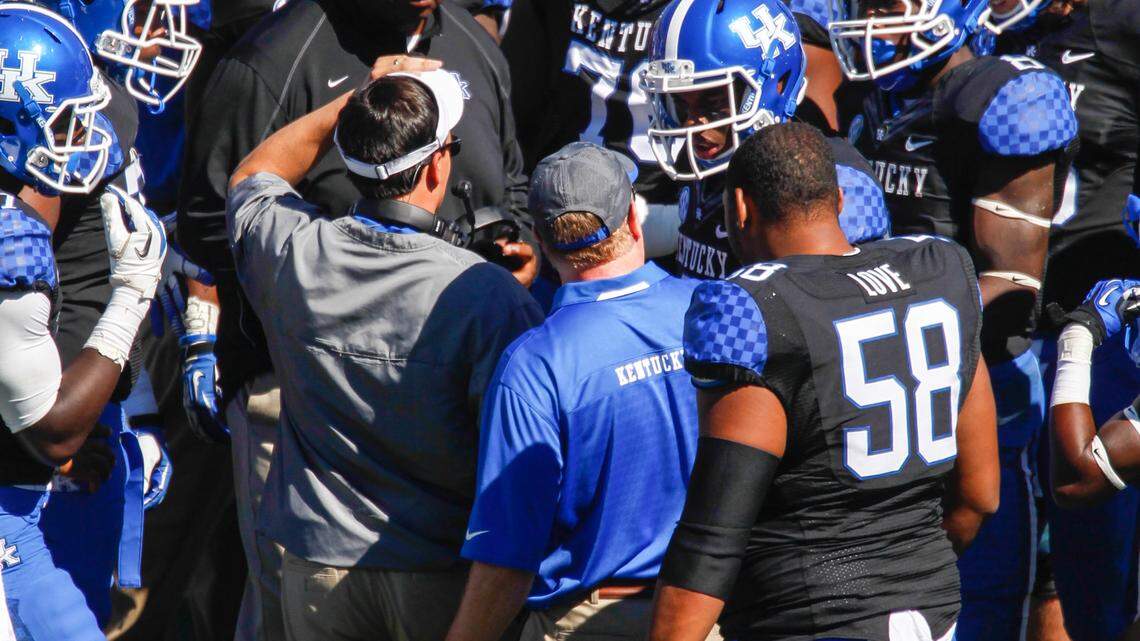 Kentucky Wildcats offensive coordinator Neal Brown and Kentucky Wildcats head coach Mark Stoops talks to the offense as the University of Louisville defeats the University of Kentucky 27-13 at Commonwealth Stadium in Lexington, Ky. on September 14, 2013.  Photo by Mark Mahan