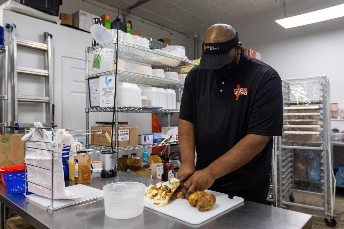 Wing KYng owner Thomas Williams slices potatoes to prepare for baking, Feb. 2, 2022.