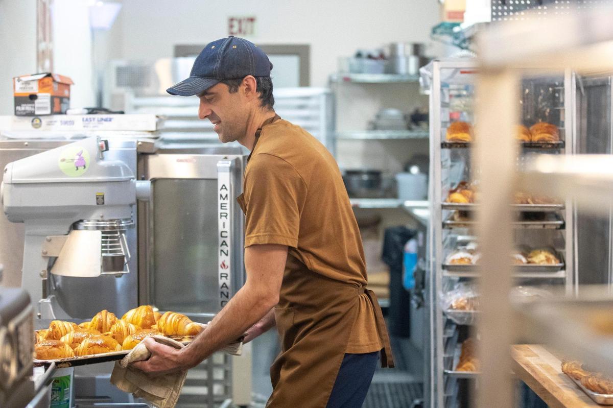 Andy Bissell takes a pan of croissants out of the oven at the bakery.