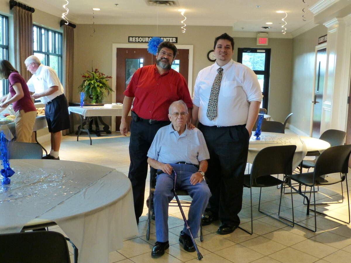 Edgar Castro at his 80th birthday, with his son, Juan, on his left, and his grandson, Victor on his right.
