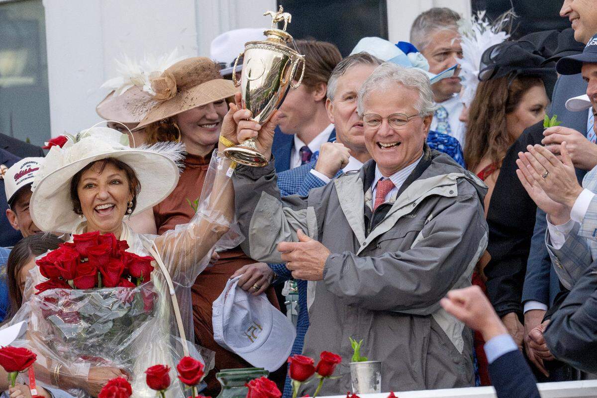 Trainer Bill Mott and his wife, Tina, celebrate with the trophy after Mott’s horse, Sovereignty, won the 2025 Kentucky Derby.