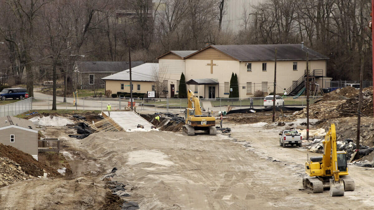 Construction continued on a box culvert along a former section of DeRoode Street on Friday as part of the Newtown Pike extension project in Lexington. The Nathaniel Mission, which eventually will have to be relocated, is at right.