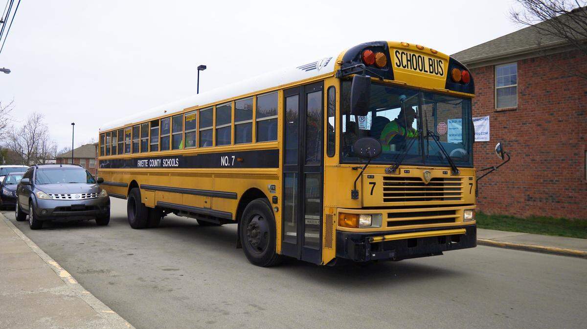 School employees of Picadome Elementary arrive to give packaged meals to students at a bus stop as part of the Bus Bites program, which aims to give kids food while Fayette County schools remain closed during the week for the coronavirus pandemic. March 16, 2020.