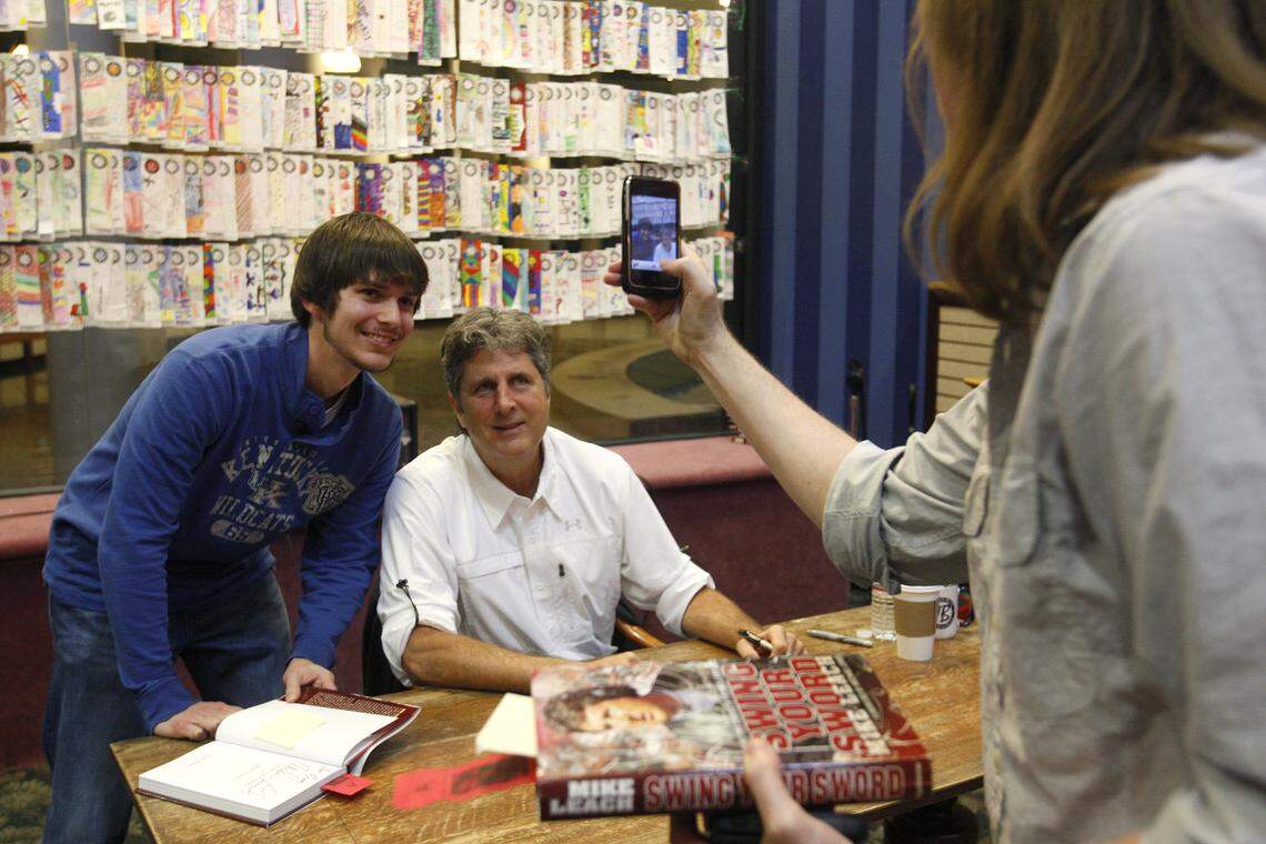 Devin Hylton of Pikeville took a photo of Eric Mitchell, left, of Elizabethtown with Mike Leach, the former Kentucky assistant football coach and current Mississippi State head man, at a signing for Leach’s book, “Swing Your Sword,” at Joseph-Beth Booksellers on November 7, 2011.