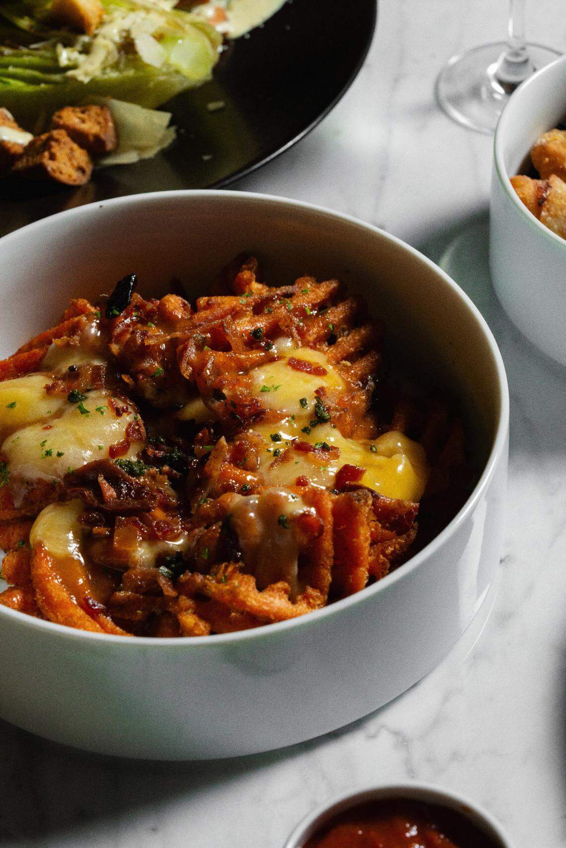 Cypress & Oak’s Frankfort Poutine is sweet potato fries, gravy, cheese curds, bourbon maple glaze with applewood smoked bacon and fried sage.