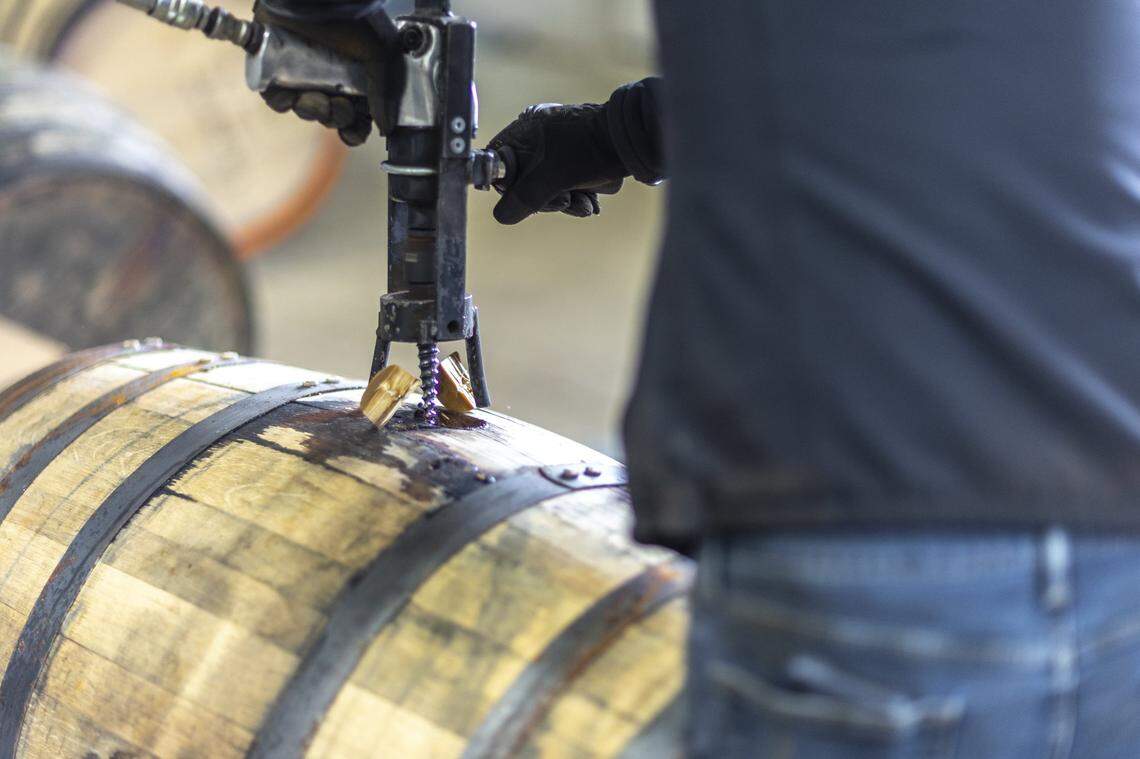 A bourbon barrel is drilled open at Bardstown Bourbon Company in Bardstown, Ky., on Wednesday, Nov. 19, 2025.