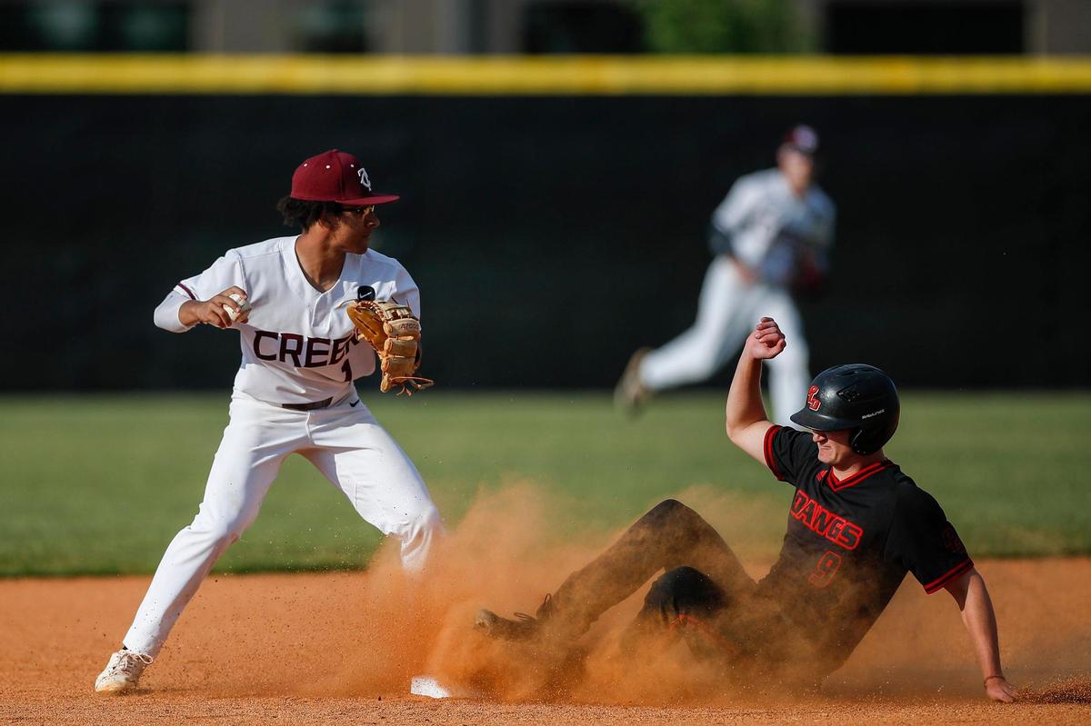 Paul Laurence Dunbar’s Scott Kendrick (9) slides into second base while Tates Creek Cooper Jackson tries to turn a double play during their game at Tates Creek on April 26.