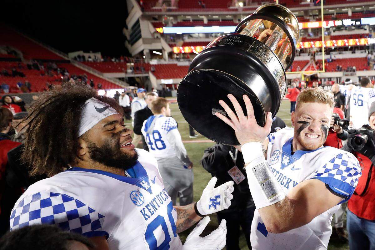 Kentucky quarterback Will Levis (7) celebrates with the Governor’s Cup after the Wildcats defeated Louisville 52-21 at Cardinal Stadium last season.