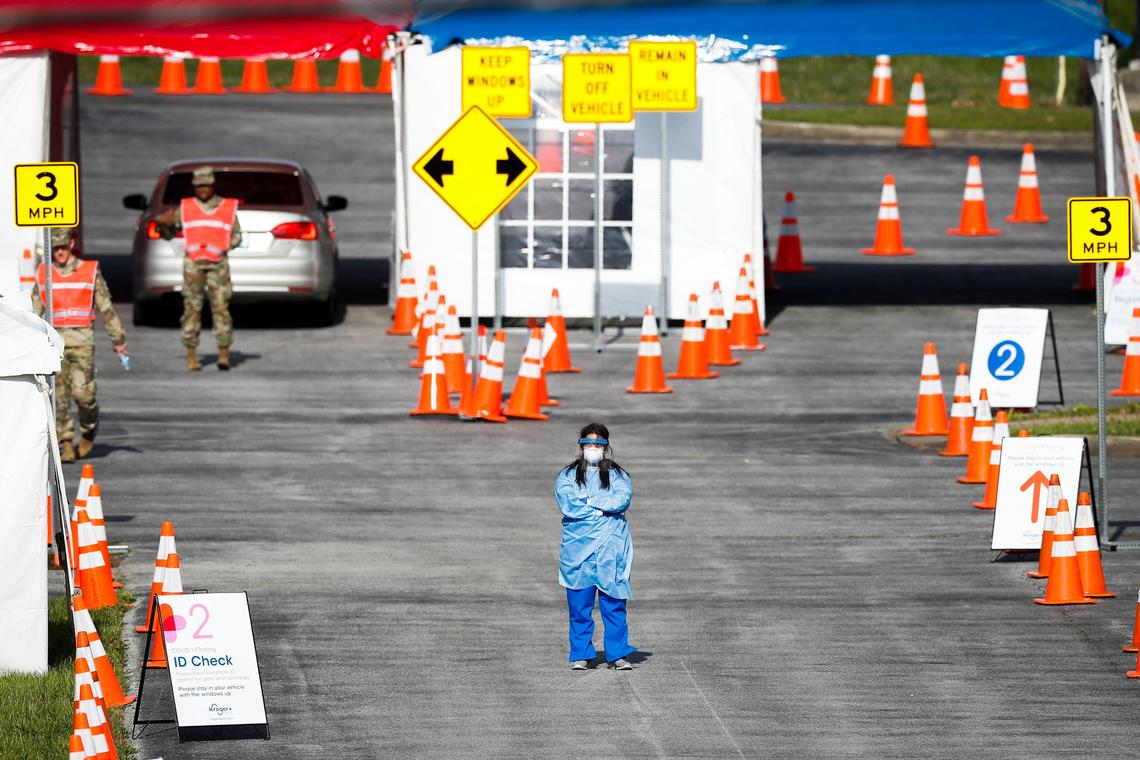 A healthcare worker and members of the National Guard wait for patients at a drive-in testing site in the parking lot of the Center for Rural Development in Somerset, Ky., Tuesday, April 21, 2020.