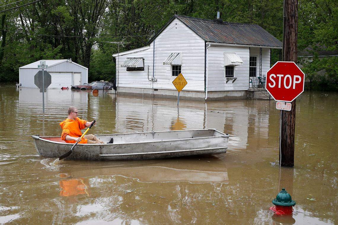 Damian Coy paddles a boat along a flooded West Pearl Street to pick up a friend in Cynthiana, Wednesday, May 20, 2020. The Licking River, which runs through Cynthiana, crested at 22.4 feet flooding the surrounding neighborhoods.