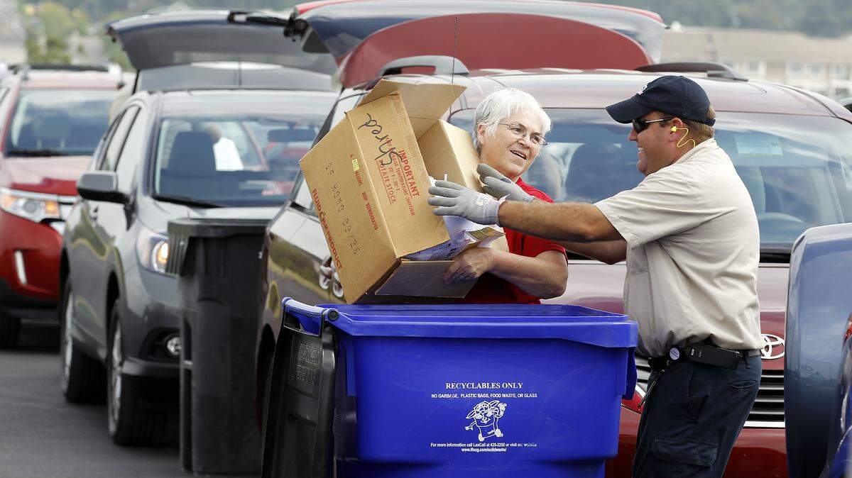 Cintas employee Andrew Hunt helped Kathleen Jennings dump her documents Tuesday at a paper-shred event held at the old landfill on Old Frankfort Pike.