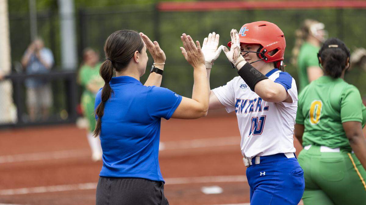 Madison Central’s Kate Drury, right, celebrates her RBI single in the first inning with first base coach Sydney Vaughn during the 11th Region Softball Tournament championship game at George Rogers Clark High School in Winchester on Saturday