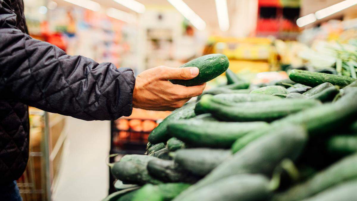 A shopper browses cucumbers in a grocery store in this stock image.