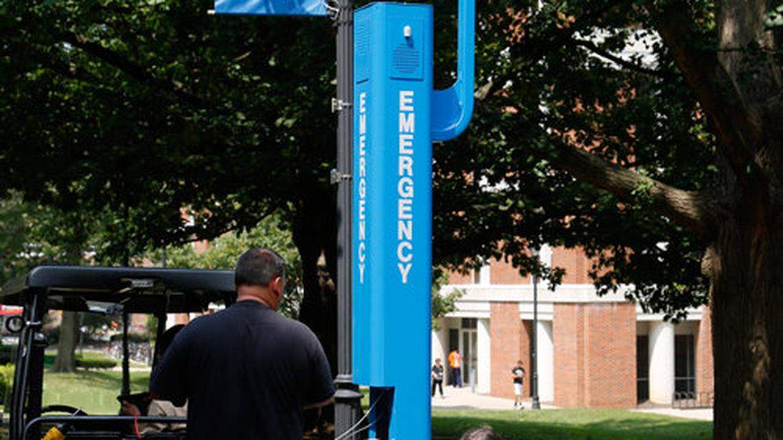 Lee Lewis, left, and Mark Welnicki with Dallman Systems, Inc., installed one of 26 new blue emergency phone boxes on the UK campus, this one next to Memorial Hall Monday, Aug. 26, 2013. The system also includes a video camera and a speaker for an outdoor emergency notification system. Photo by Ron Garrison | Staff