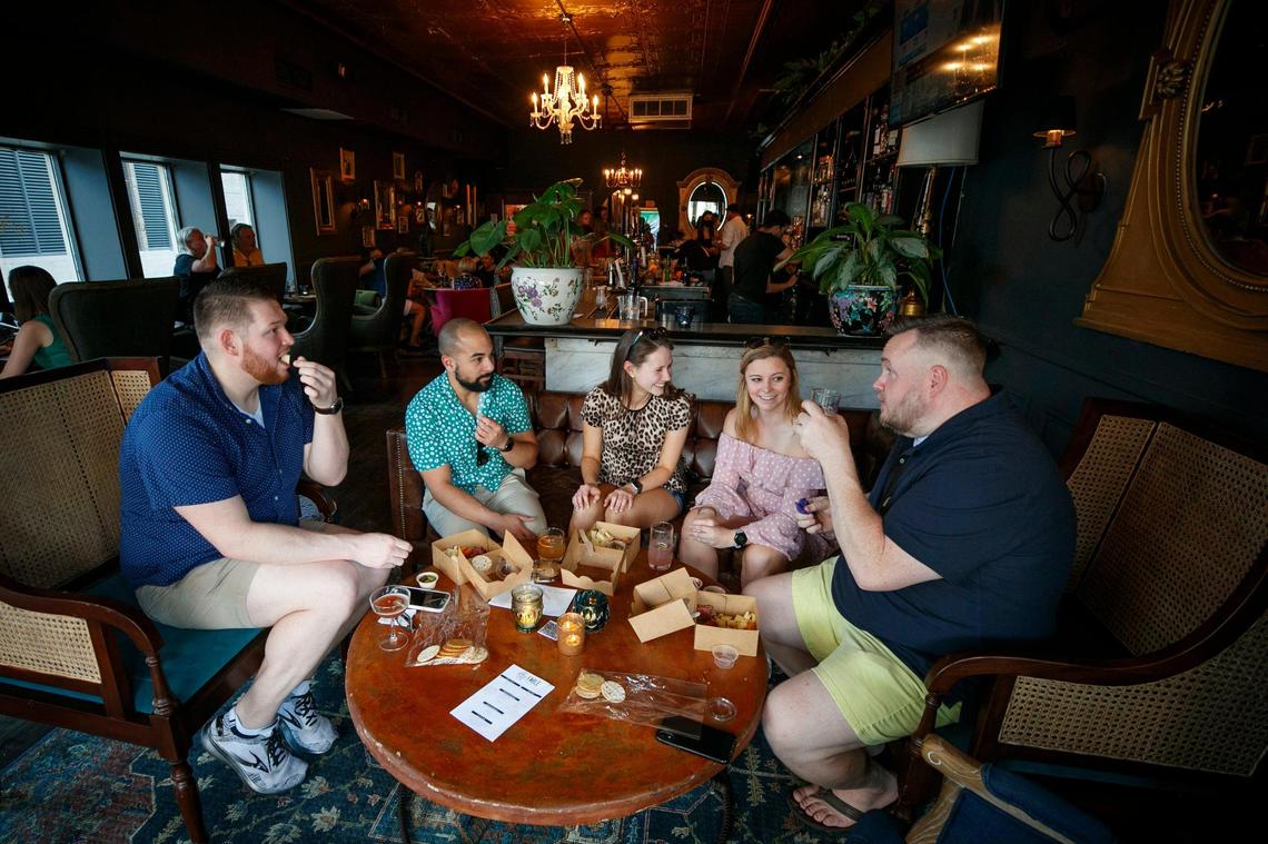 Brandon Lock, of London, Ky., from left, Manny Williams, Lex, Yulia Perevozchikova, Molly McKenna, and Jason Ervin, all of Lexington, Ky., share snacks and drinks at The Grove in Lexington, Ky., Thursday, May 27, 2021. The Grove is collaboration space between Harvey’s Bar and beer garden, Fable, which offers wine and charcuterie boards, Luna, a food truck and a new event space called The Melodeon.