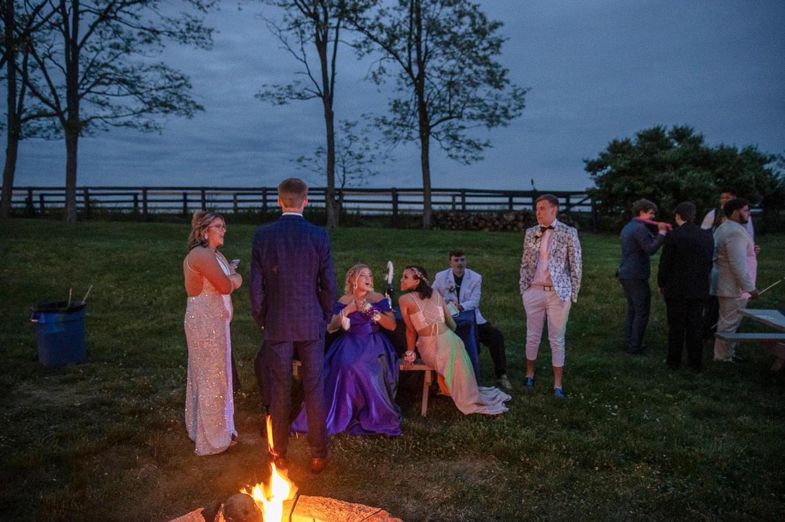 Macy Dungan, left, and her friends talk by one of the fire pits at Vineyard Vines in Versailles, Ky., on Saturday, May 15, 2021, where their prom was held.