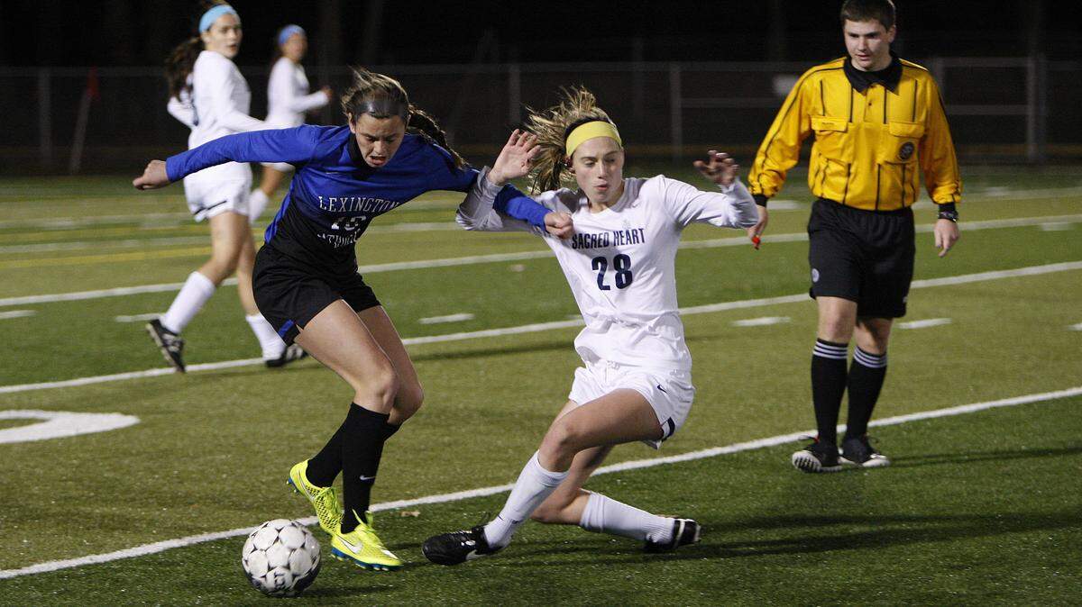 LexCath's Kennedy Tranter, left, fouled Sacred Heart's Catherine Fell in the state finals Saturday at Paul Dunbar. Tranter came close to a goal when she hit the crossbar in the 62nd minute.    