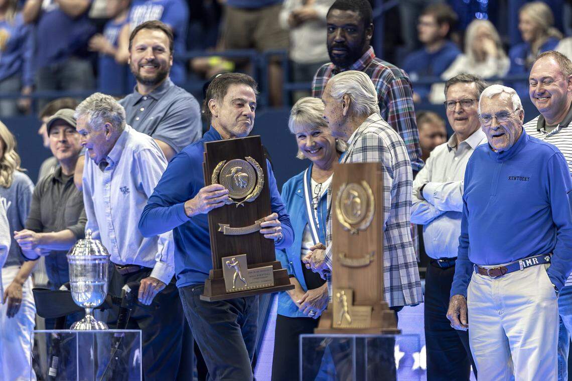 Former Kentucky basketball coach Rick Pitino carries UK’s 1996 national championship trophy to the court before being re-introduced to the Big Blue Madness crowd in Rupp Arena on Friday night.