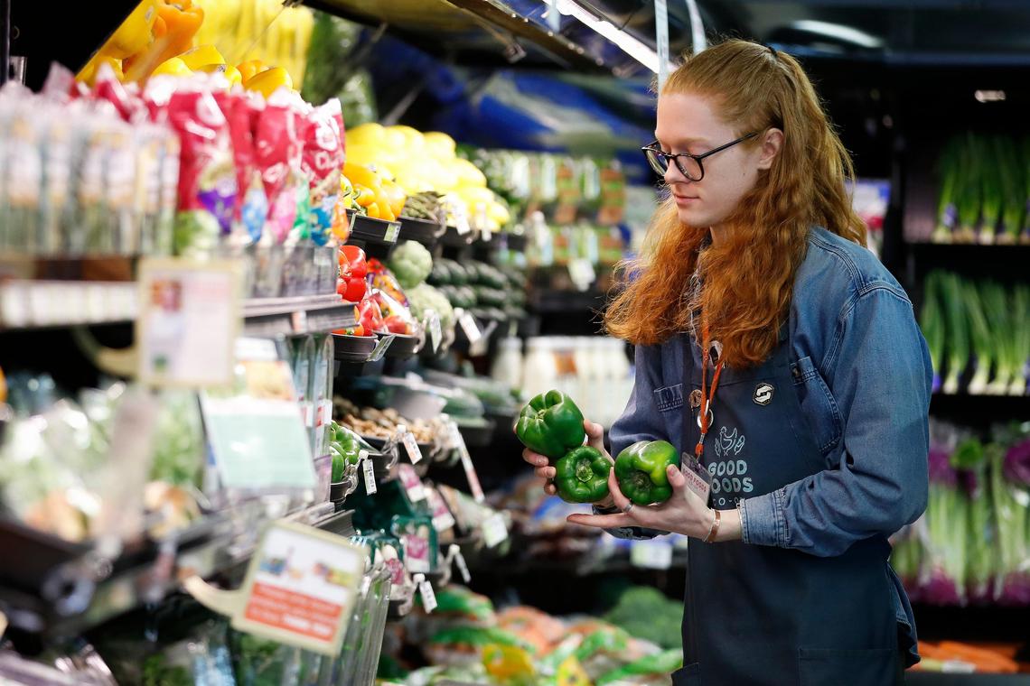 Luke Blankenship restocks bell peppers at Wednesday Good Foods Co-op.