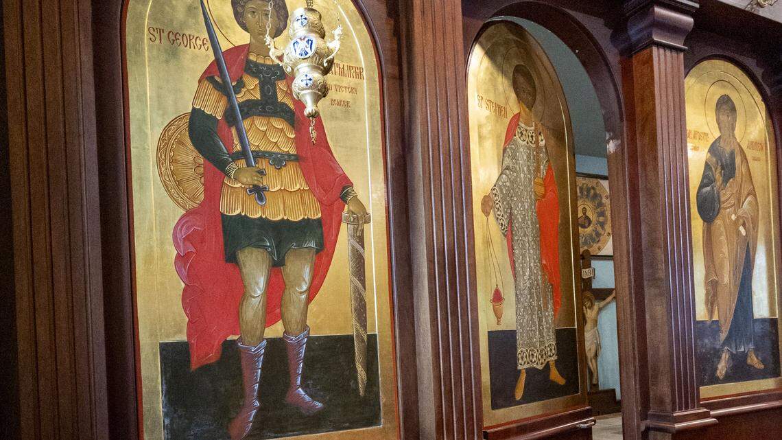 A door from the nave leads back to the high altar inside St. Andrew Orthodox Church, photographed Dec. 1, 2025 in Lexington, Ky. The solid mahogany wall is covered with icons that include scenes from the lives of Christ, Mary, Orthodox feast days, and American Orthodox saints and inscriptions.