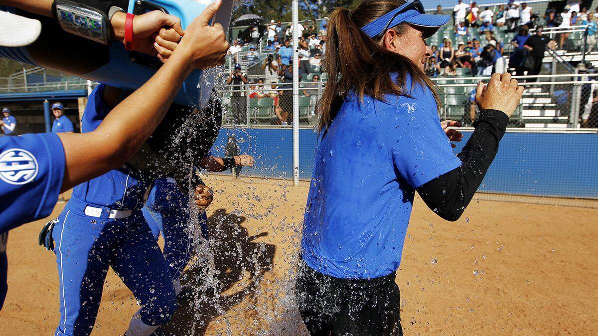 Kentucky softball players doused their head coach, Rachel Lawson, on Sunday after the Cats won back-to-back games over UCLA to earn the program's first-ever berth in the Women's College World Series.    