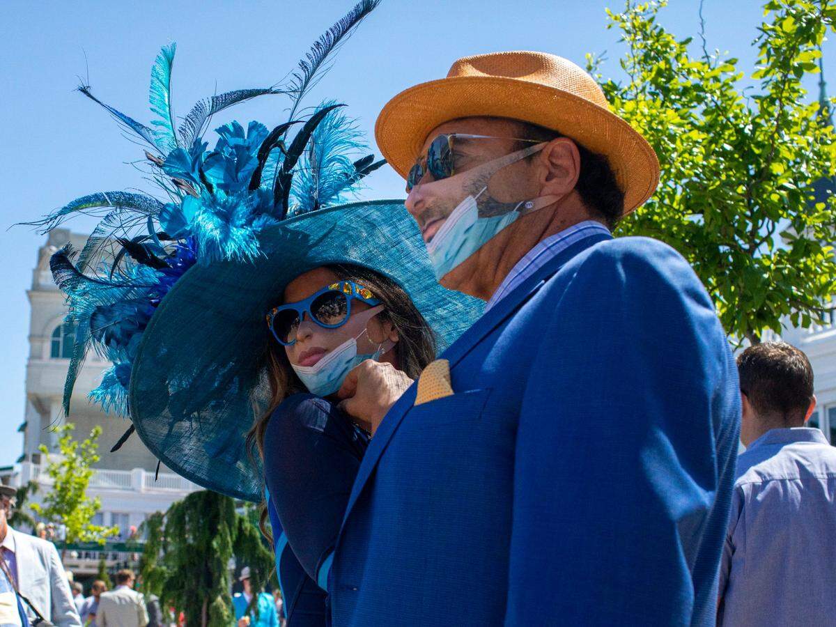 Dr. Garth Fisher and his partner, SueLynn Medeiros of Beverly Hills, Calif. pose for a photo taken by a fascinated Derby attendee at Churchill Downs in Louisville, Ky.. Saturday, May 1, 2021.