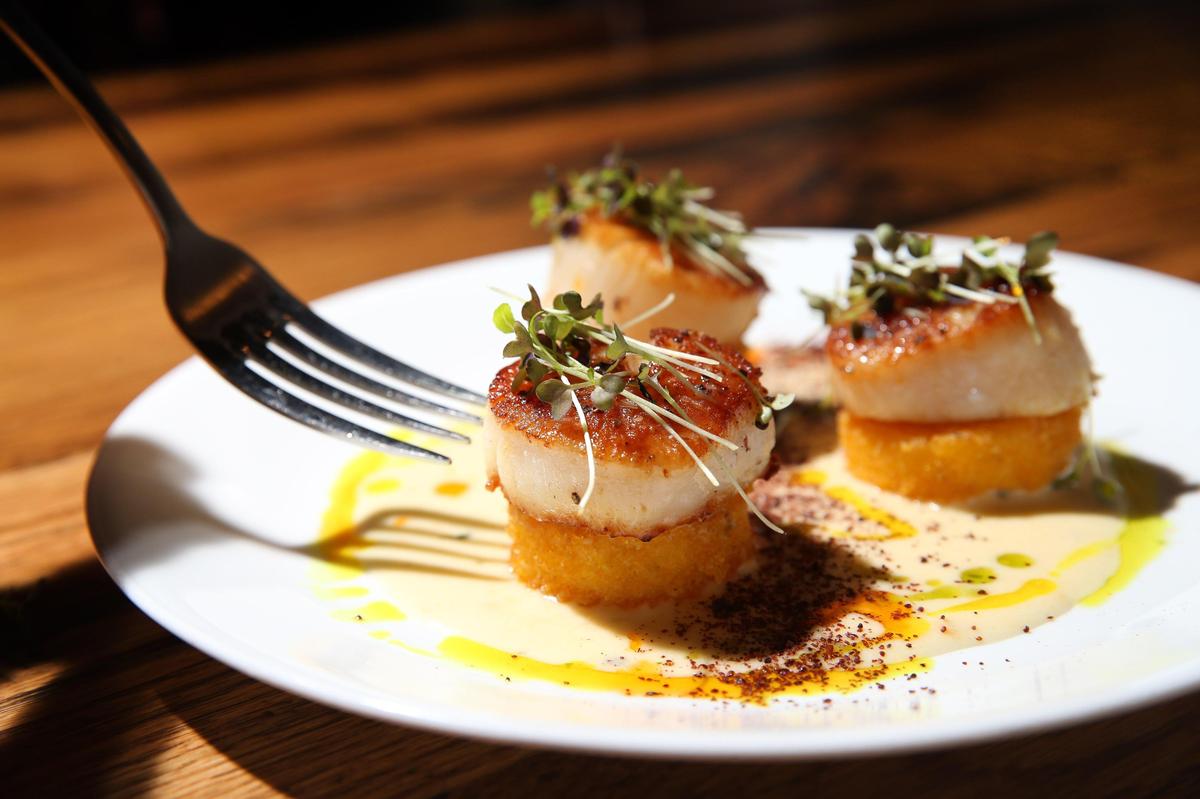 A scallop starter at Graze featuring seared diver scallops, baba ganoush, peppa dew cooli and pine nuts.