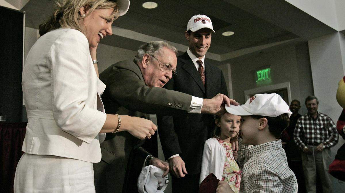 Walker Horn (foreground in cap) was 4 years old in 2008 when the University of South Carolina’s President, Andrew Sorensen, placed a hat on his head during the introduction of Darrin Horn, Walker’s father, as the Gamecocks’ new head men’s basketball coach. Next season, Walker Horn will be a Kentucky Wildcats walk-on basketball player.