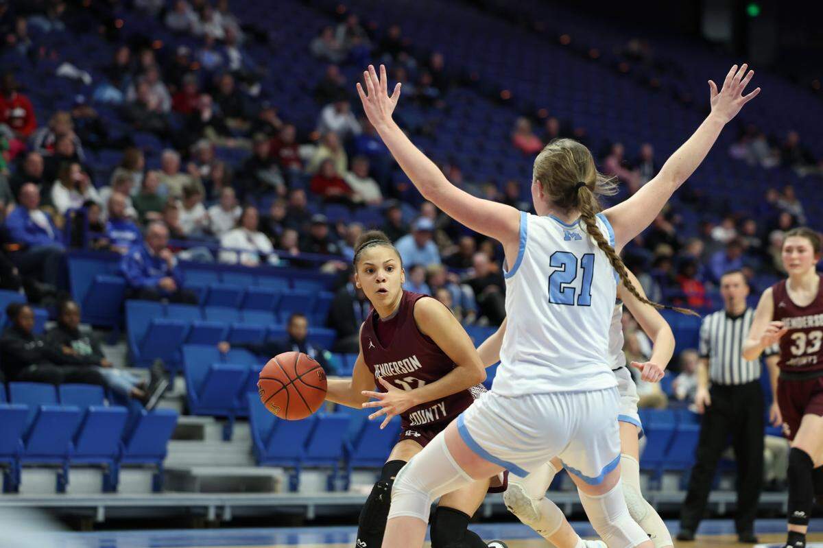 Henderson County’s Shalyn Sprinkles looked for room to pass around Mercy’s Olivia Pifer. Sprinkles led Henderson County with 21 points.