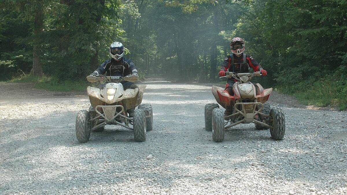 Two riders on ATVS explore the off-highway trails of Turkey Bay at Land Between the Lakes in Kentucky. 
